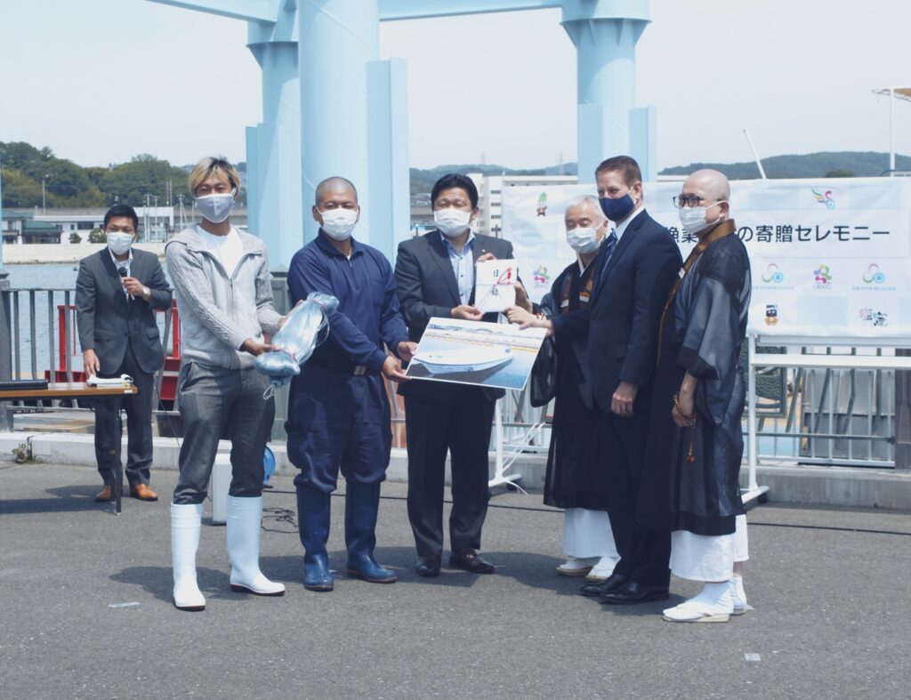佐藤市長（中央）に寄贈品の目録を渡す戸松理事長（右から３人目）ら